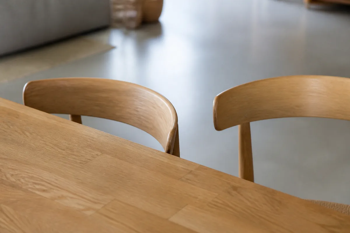 Table de réunion en bois clair et deux chaises vides face à face dans une petite entreprise