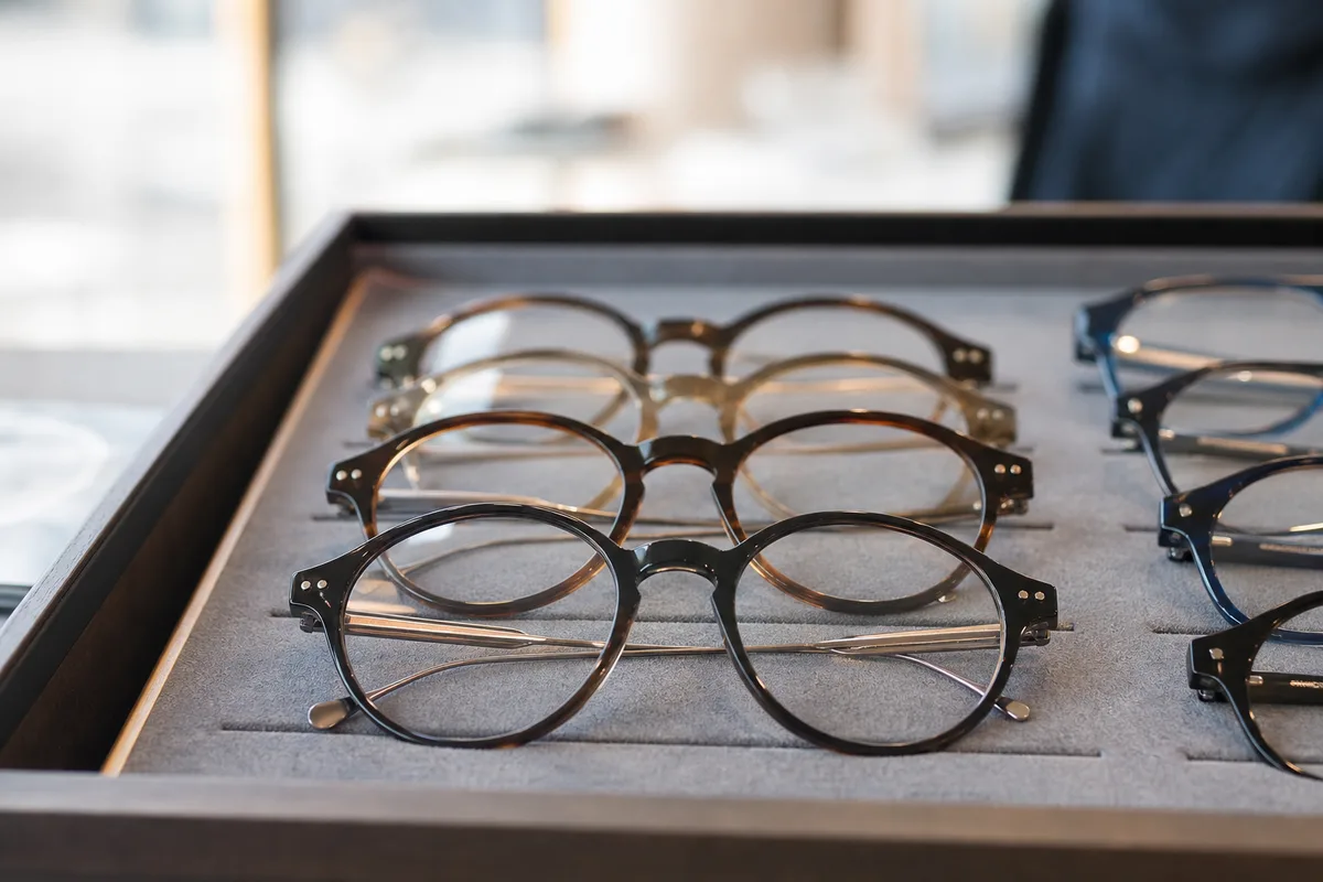 Montures de lunettes alignées sur un plateau en feutre gris dans un cabinet d’optique français