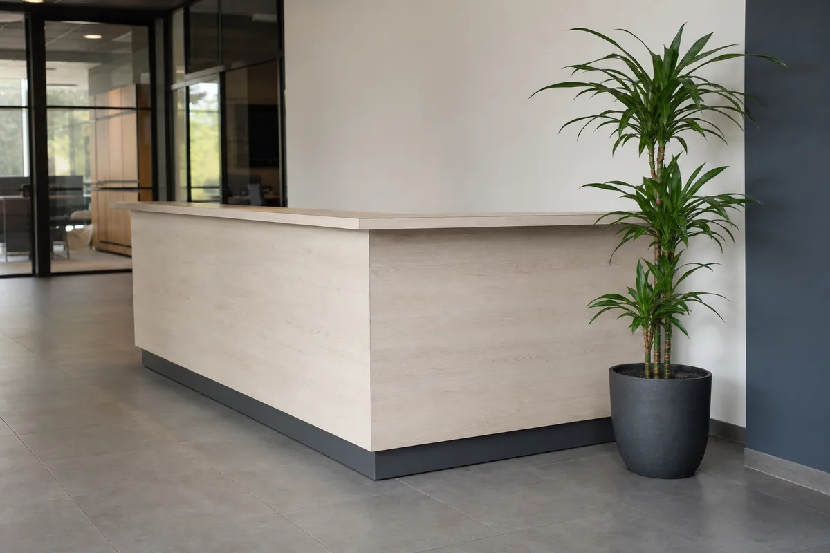 Comptoir d’accueil vide dans les locaux d’une PME française, plante verte et sol carrelé